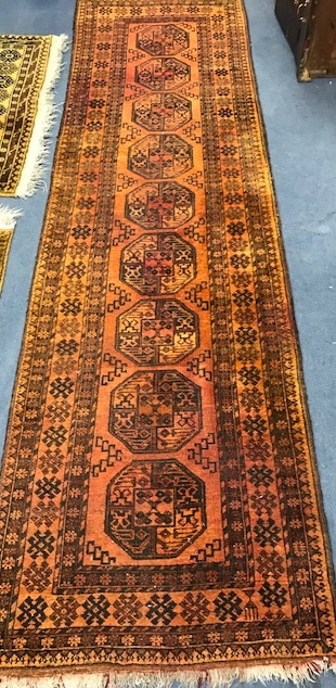 A Persian rust coloured runner, woven with a row of octagons 297 x 85cm.